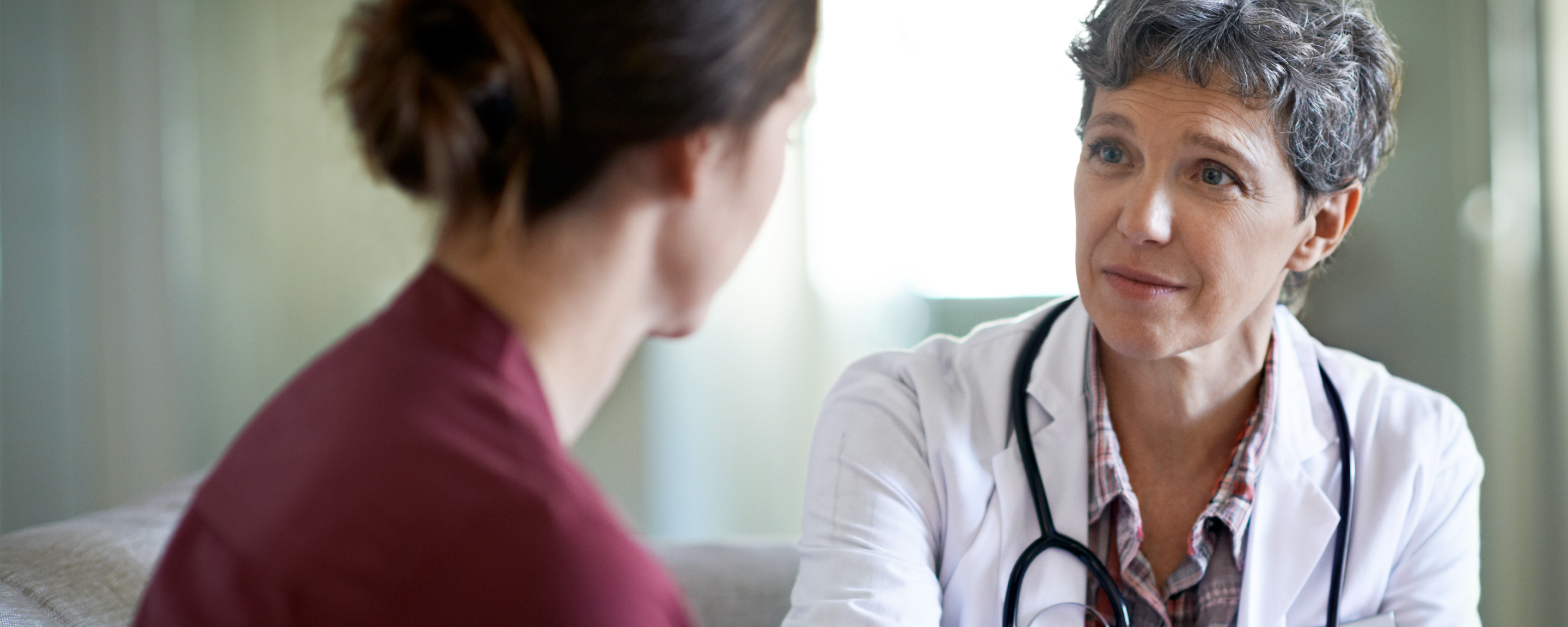Woman physician talking with pregnant woman